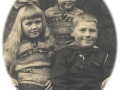 Børn af baneformand på Vind station, Jens Severin Jensen (1890-1961) og hustru, stationsforstander Karen Julie Jensen (f. Larsen, 1897-1972). Forrest sidder Bothilde Marie Jensen (g. Frydendal, 1923-1997) og Niels Peter Jensen (ændr. Øvind, 1922-1994). Bag dem står Ellen Kathrine Jensen (g. Mikkelsen, 1926-2014). Omkring 1930.