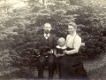Lærer Niels Peter Larsen Straasø (1873-1947) og hustru Kirsten Larsen (f. Frederiksen, 1883-1958) fotograferet med deres ældste søn, Lars Erik Bernhard Larsen Straasø (1910-1981) i haven i Stråsø i 1913.