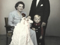 Anders Thusgaard Mathiasen (1904-1987) og Signe Mathiasen (f. Pedersen, 1904-1986), Vind Kirkeby, fotograferet i 1949 med deres to yngste børn, sønnen Finn Thusgaard Mathiasen (1946-1995) og datteren Irma Thusgaard Mathiasen i dåbskjole.