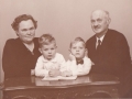 Landpost og husmand i Vildkilde, Daniel Mikkelsen (1899-1976) og hustru Anine Kirstine Marie Mikkelsen (f. Nielsen, 1907-1997) fotograferet med børnebørnene Hans (t.v.) og Niels (t.h.). Midten af 1950\'erne.