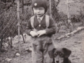 Jens Kristian Svendsen, søn af husmand i Blåbjerghus Peder Svendsen (1908-1994) og Oda Kathrine Svendsen (f. Andersen, 1915-1986) fotograferet med hunden 'Kvik' i begyndelsen af 1940'erne. For yderligere oplysninger, se menupunktet 'Vind i billeder' -> 'Månedens billede, april 2017'.