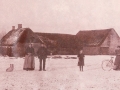 Vester Skovgård fotograferet omkring århundredeskiftet. Stående til venstre med hunden formentlig gårdmand Jens Iversen (f. 1859) og hans hustru Mette Marie Iversen (f. Mohrsen, 1843-1911). Pigen i midten og parret til højre har ikke kunnet identificeres. I baggrunden til højre genkendes tydeligt Vind kirke.