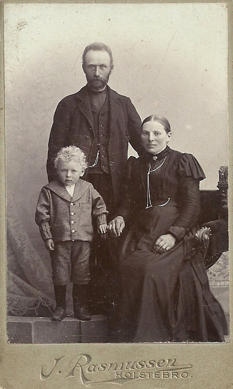 Sognefoged og ejer af Voldstedgård, Jens Jensen Voldsted (1860-1923) fotograferet med sin hustru Jensine Kirstine Voldsted (f. Christensen, 1866-1931) og sønnen Jens Kristian Jensen Voldsted (f. 1896). Omkring 1900.