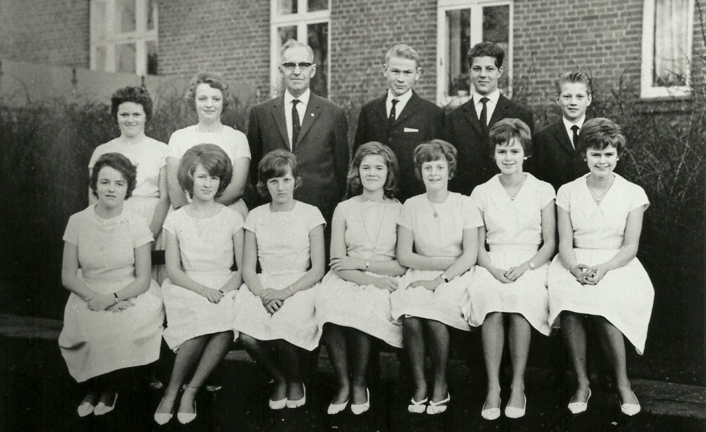 Konfirmation, 1964. Siddende fra venstre: Elly Bækdahl, Elisabeth 'Lisbeth' Rahbek, Doris Damgaard, Gunhild Pedersen, Karen Margrethe Kirkegaard, Janne Frydendal og Karen Frydendal. Stående fra venstre: Ellen Svendsen, Paula Nielsen, sognepræst Frederik Olesen Sigh, Hardy Mogensen, Kaj Madsen og Leif Jacobsen.