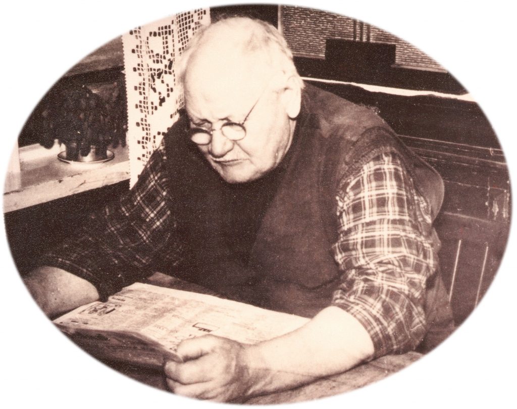 Nis Jørgen Hansen (1877-1965) studerer dagens avis. Årstal ukendt. Se flere billeder af Nis Jørgen Hansen og hans familie under menupunktet 'Vind i billeder' -&gt; 'Folk og fæ'.
