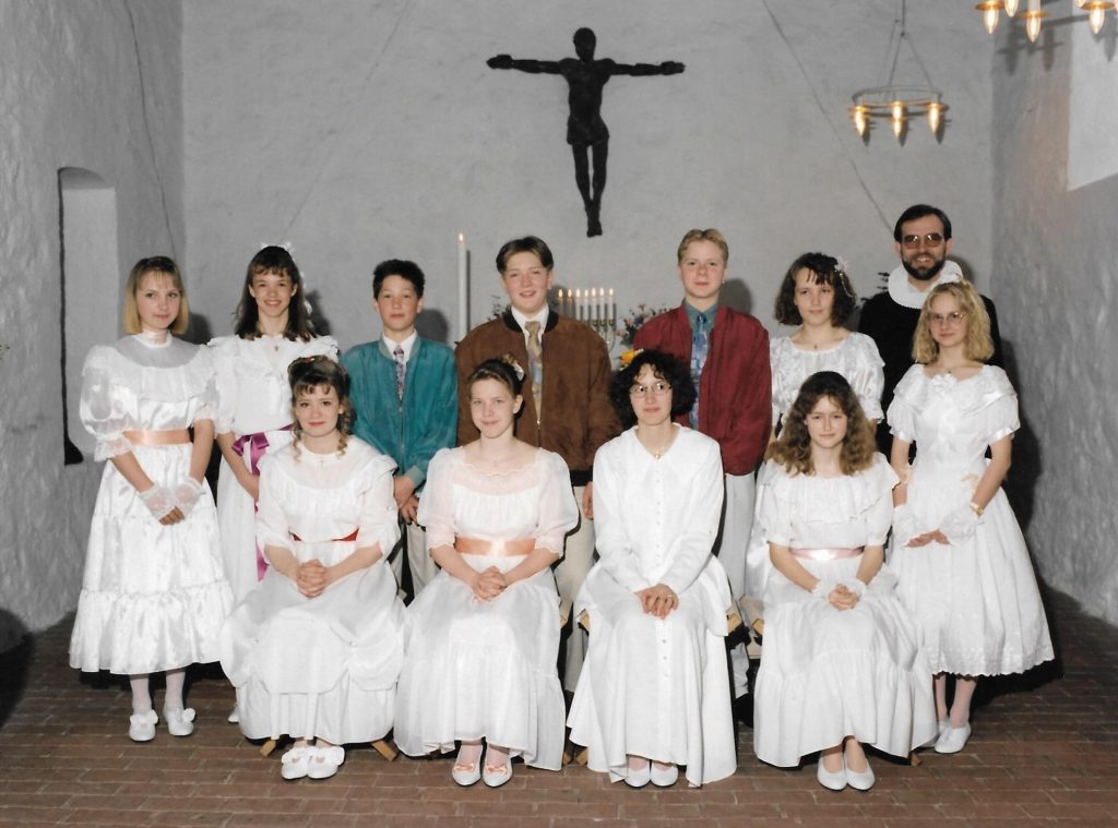 Konfirmation i Vind kirke, foråret 1994. Siddende fra venstre ses Lea Bjerg Mogensen, Winnie Trankjær, Christina Sebbelin Pedersen og Sanne Christensen. Stående fra venstre ses Mona Bendtsen, Maibrit Jensen, Rasmus Brun, Brian Nørgaard Poulsen, Rune Bødker, Louise Svenstrup, pastor Morten Mouritzen og Marianne Hansen.