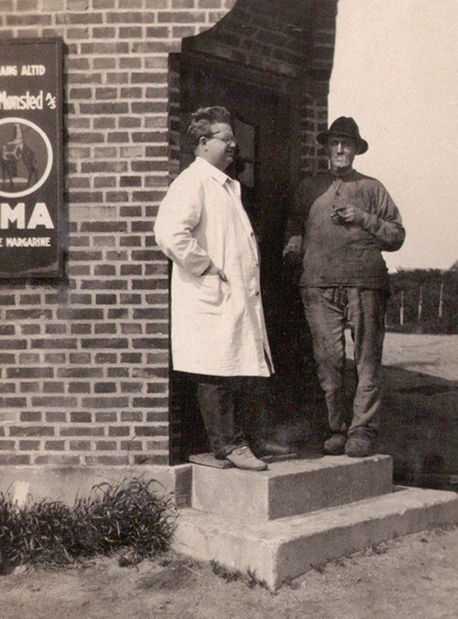 Købmand Halkjær fotograferet på trappen foran sin forretning. 