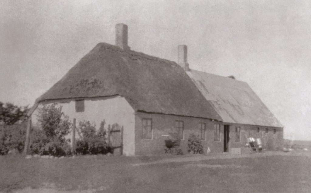 Det tidligst kendte fotografi af Kristiansminde, indrettet med beboelse i den stråtækte del nærmest kameraet og med stald i den anden. Årstal uvis, formentlig fra omkring 1920.